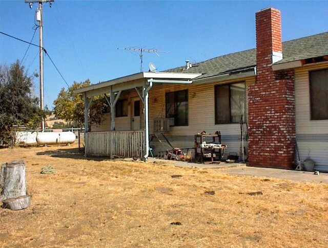 7081 Live Oak, Wonder Valley, CA 93657 - exterior space featuring a chimney, covered porch, and roof with shingles