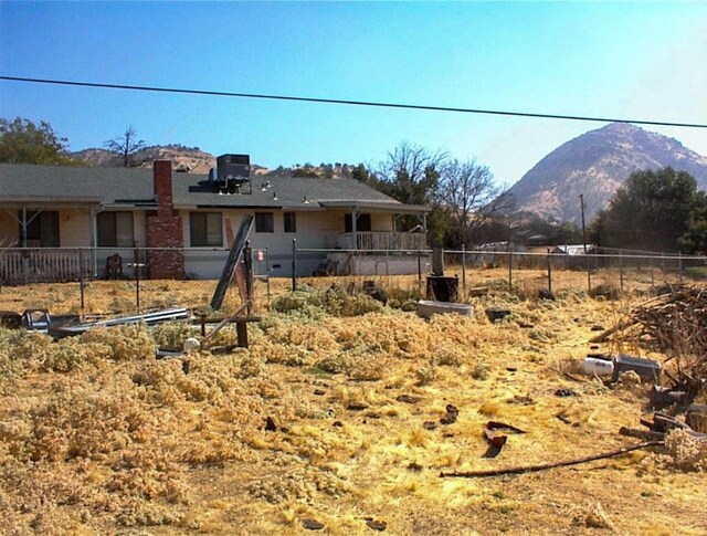 7081 Live Oak, Wonder Valley, CA 93657 - rear view of property featuring fence, a chimney, and a mountain view