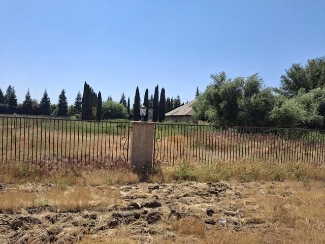view of yard with a rural view and fence