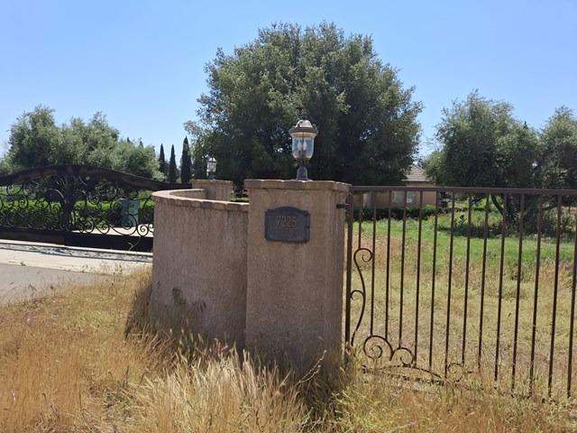 view of gate with fence and a lawn