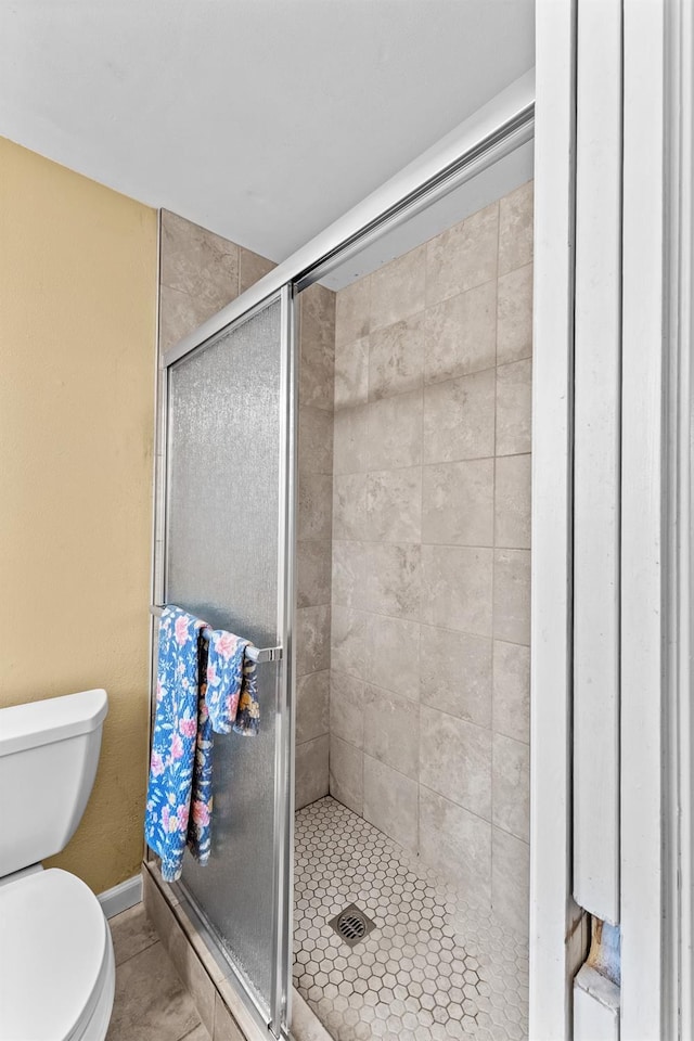 full bathroom featuring toilet and a stall shower