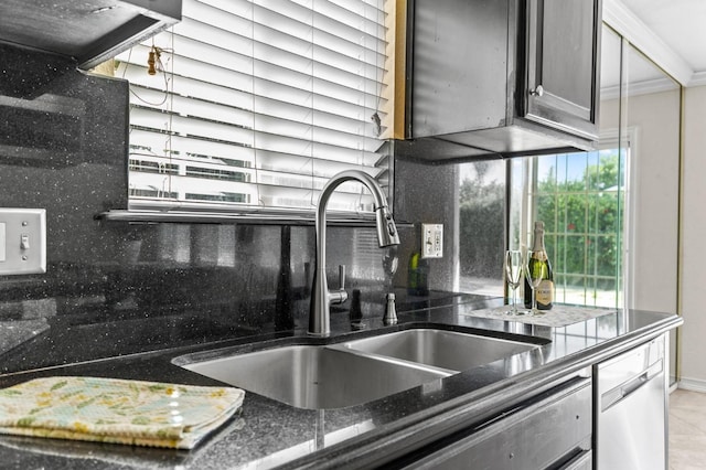 kitchen with stainless steel dishwasher, crown molding, tasteful backsplash, dark stone countertops, and a sink