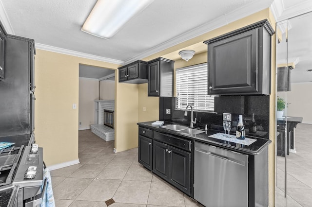 kitchen featuring a sink, light tile patterned flooring, dark countertops, dishwasher, and a fireplace