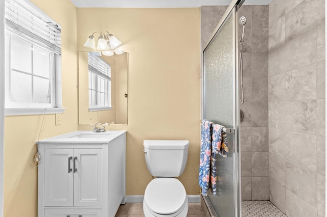 bathroom featuring tile patterned flooring, vanity, toilet, and a stall shower