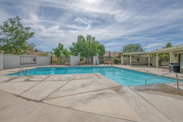 pool featuring fence and a patio area