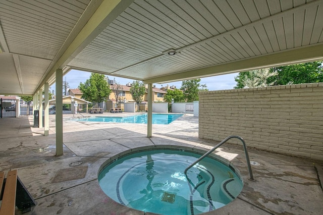 pool featuring a patio area, a hot tub, and a fenced backyard