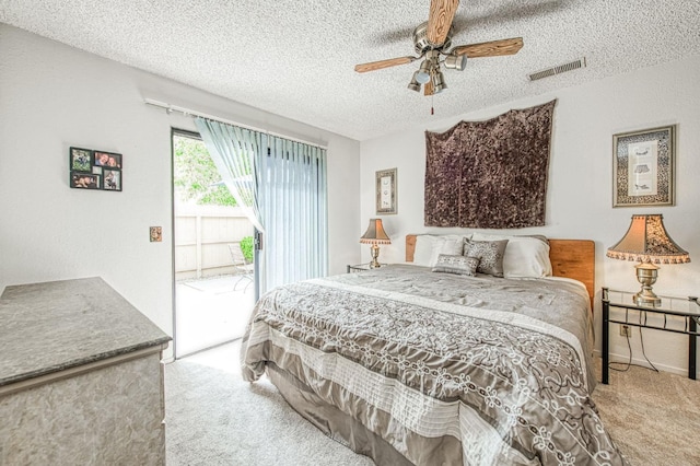 bedroom with a ceiling fan, a textured ceiling, carpet floors, access to exterior, and visible vents