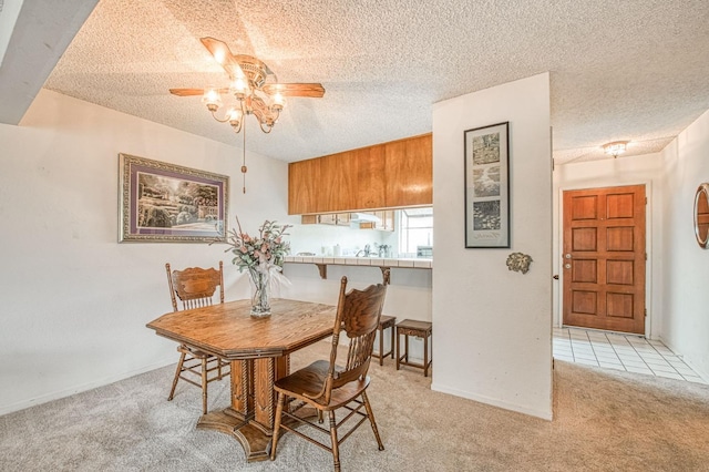 dining room with carpet, a textured ceiling, and ceiling fan