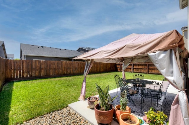 view of yard with outdoor dining space, a patio area, and a fenced backyard