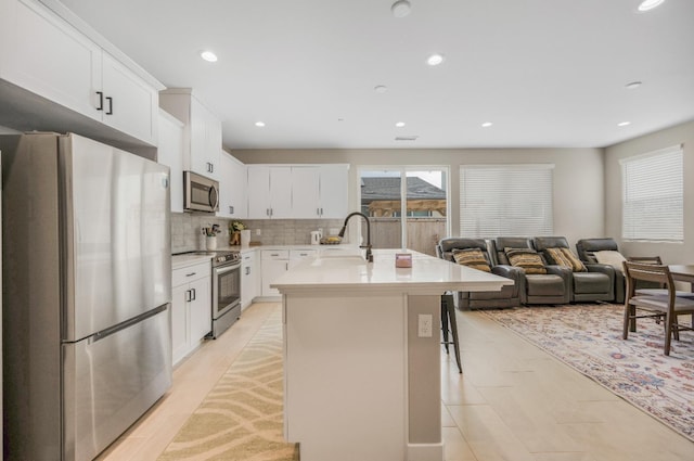 4103 Ash Rd, Madera, CA 93636 - kitchen with a sink, decorative backsplash, light countertops, an island with sink, and appliances with stainless steel finishes