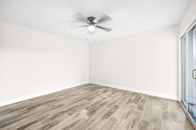 unfurnished room with ceiling fan, baseboards, wood finished floors, and a textured ceiling