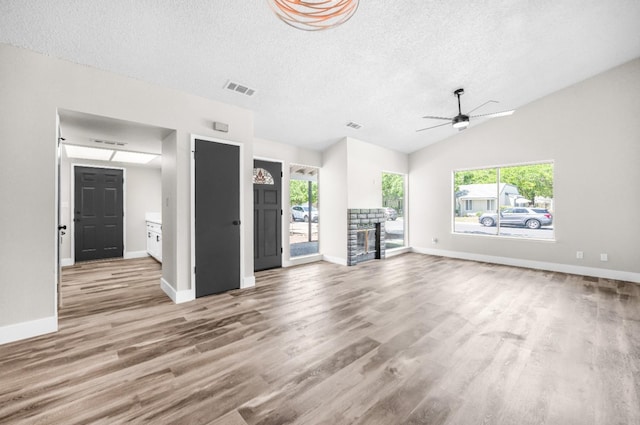 unfurnished living room with wood finished floors, visible vents, a textured ceiling, and ceiling fan