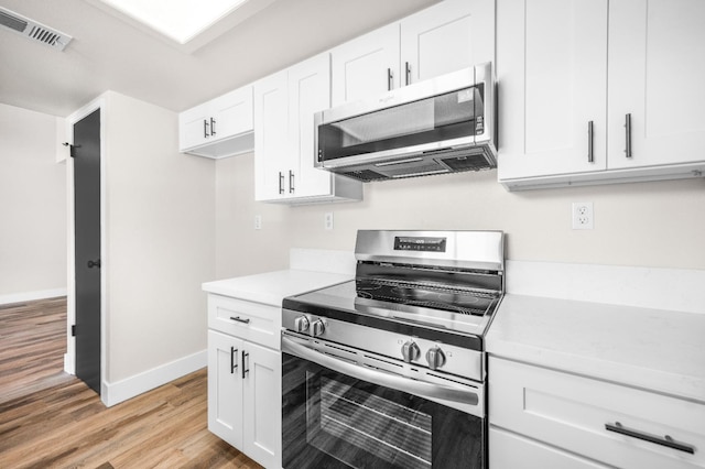 kitchen featuring light countertops, stainless steel appliances, light wood-style flooring, baseboards, and visible vents