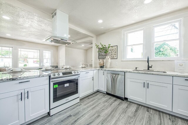 2225 N Van Ness Blvd, Fresno, CA 93704 - kitchen with stainless steel appliances, island range hood, a sink, a textured ceiling, and light stone countertops