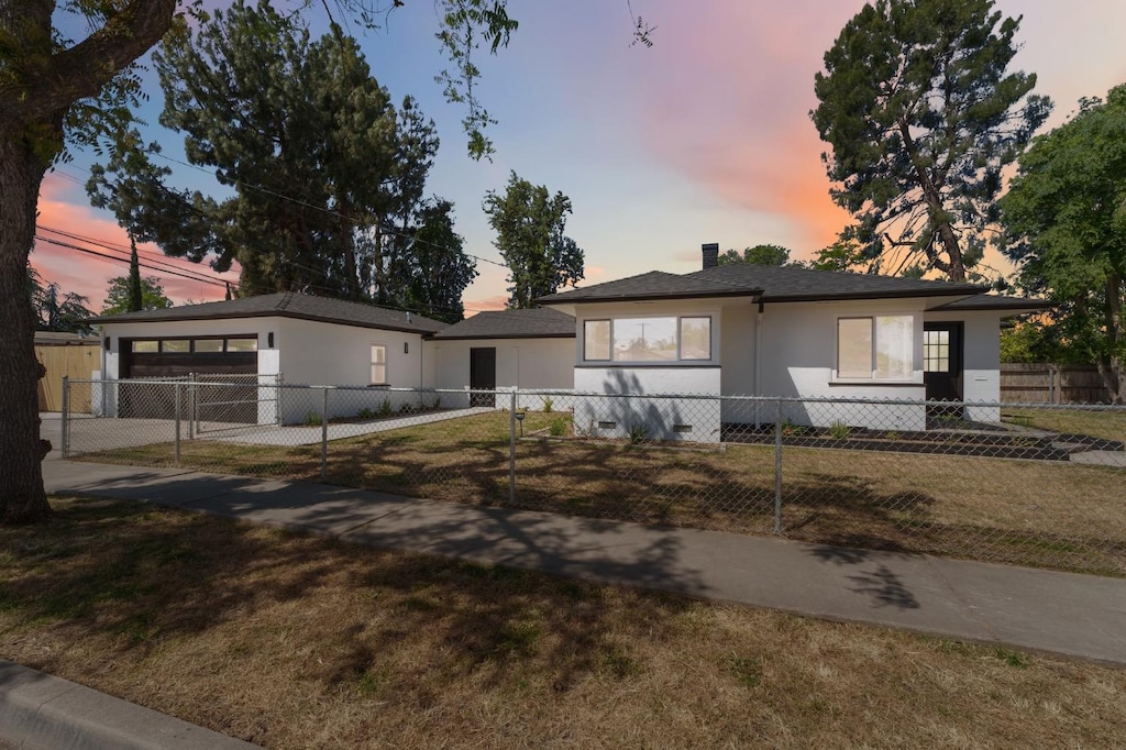 1105 W Clinton Ave, Fresno, CA 93705 - ranch-style home featuring a garage, stucco siding, a fenced front yard, and a yard