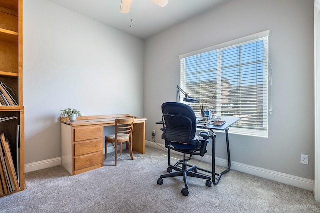 carpeted home office featuring a ceiling fan and baseboards