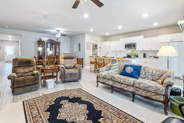 living room with light tile patterned floors, a ceiling fan, recessed lighting, and baseboards