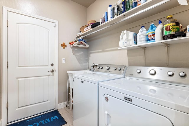 laundry room featuring light tile patterned floors, separate washer and dryer, laundry area, and baseboards