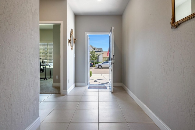 entryway with baseboards, a textured wall, and plenty of natural light