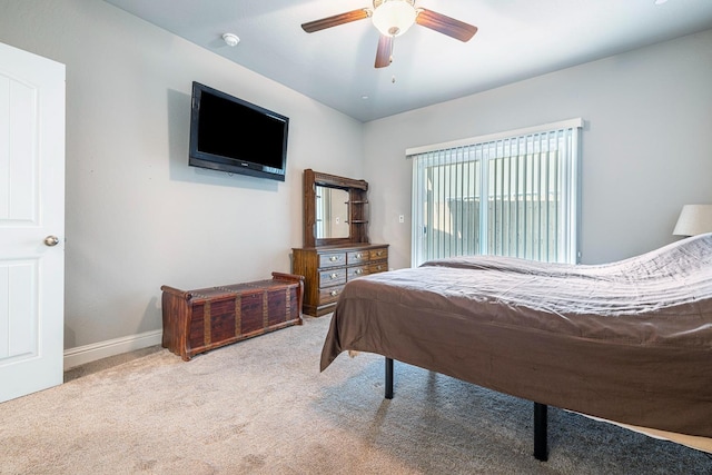 carpeted bedroom with ceiling fan and baseboards