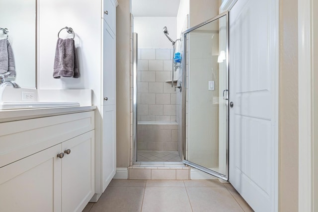 full bathroom featuring tile patterned floors, a stall shower, and vanity