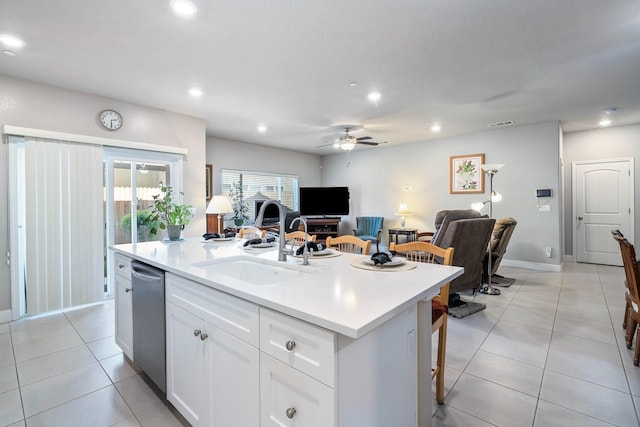 kitchen with stainless steel dishwasher, white cabinets, a sink, ceiling fan, and open floor plan