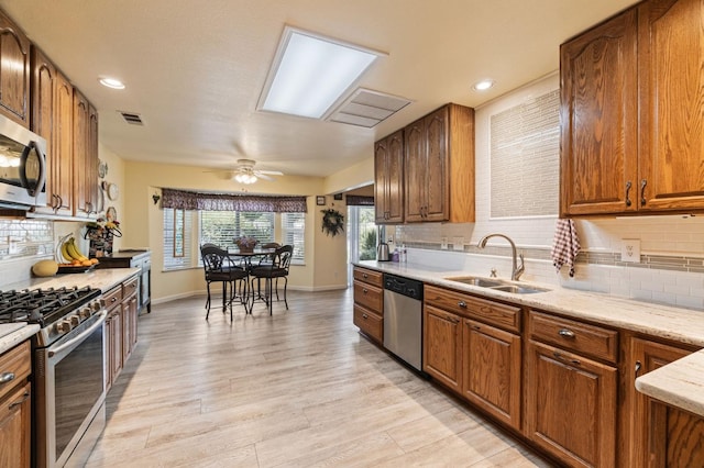 43443 Running Deer Dr, Coarsegold, CA 93614 - kitchen with a sink, decorative backsplash, light wood-style floors, stainless steel appliances, and visible vents