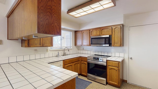 1201 Rayser St, Kingsburg, CA 93631 - kitchen with appliances with stainless steel finishes, brown cabinets, tile countertops, and a sink