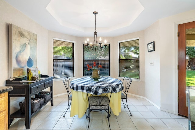 dining room with an inviting chandelier, baseboards, light tile patterned floors, and a tray ceiling