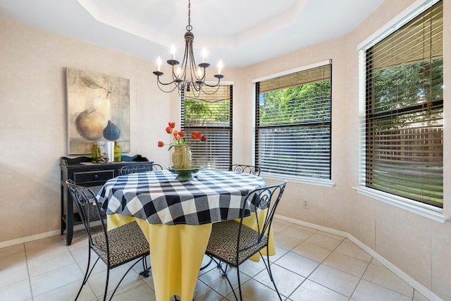 dining room with baseboards, a tray ceiling, light tile patterned floors, and a notable chandelier