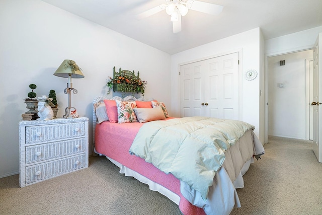 bedroom with ceiling fan, light colored carpet, and a closet