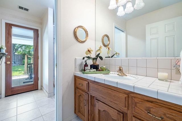 bathroom featuring backsplash, visible vents, tile patterned floors, vanity, and a chandelier