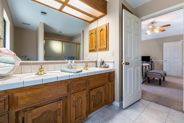 bathroom with double vanity, visible vents, a sink, and a stall shower
