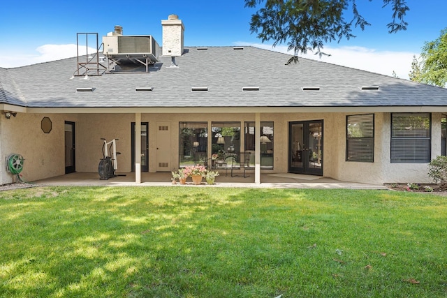 rear view of property with a patio, a yard, french doors, and a chimney