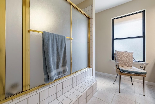 bathroom with baseboards, a shower with shower door, and tile patterned flooring