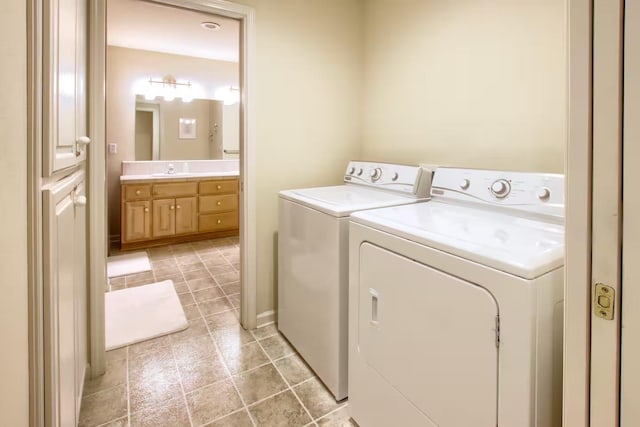 clothes washing area with light tile patterned floors, washer and clothes dryer, and a sink