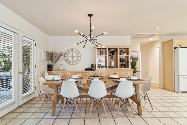dining area with light tile patterned floors and an inviting chandelier