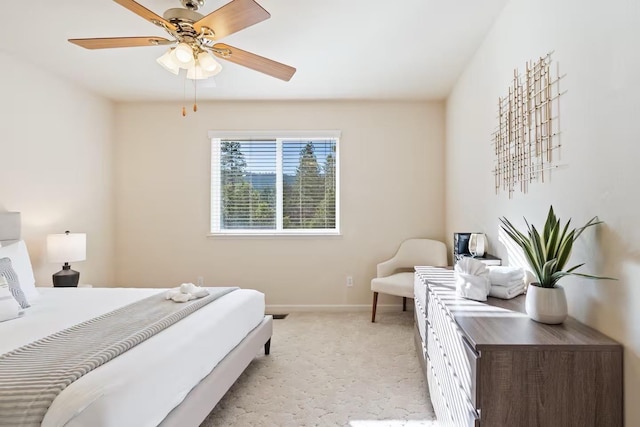 bedroom featuring light colored carpet, ceiling fan, and baseboards