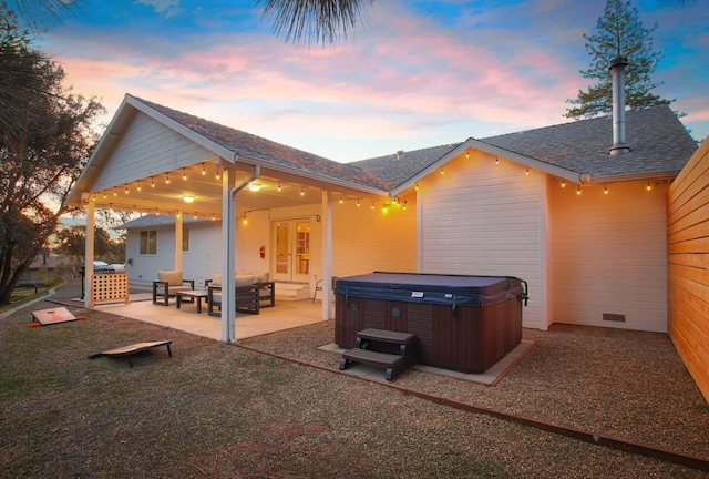 back of house featuring outdoor lounge area, a hot tub, and a patio area