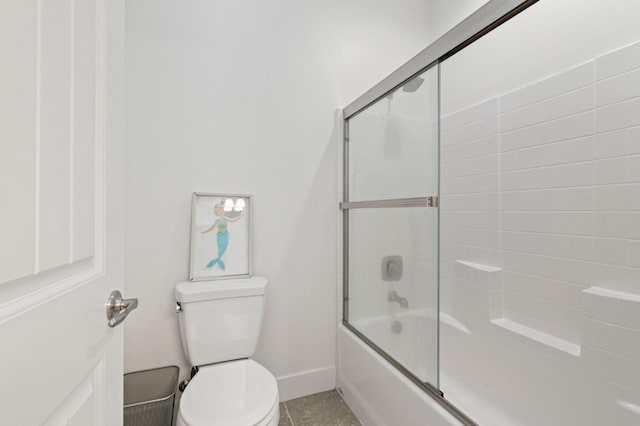 bathroom with enclosed tub / shower combo, toilet, and baseboards