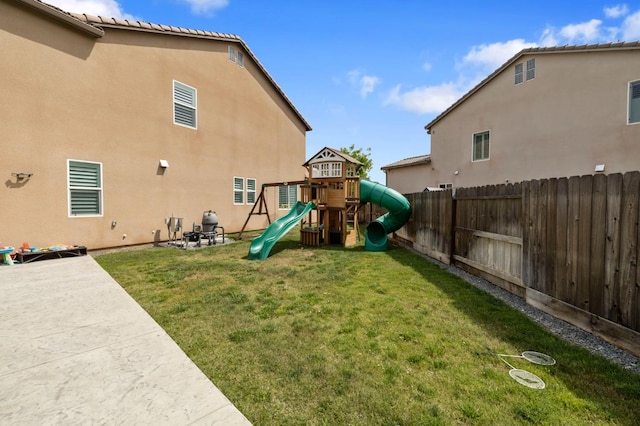 view of play area featuring a lawn, a patio, and a fenced backyard