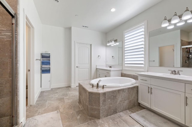 bathroom with a garden tub, two vanities, a sink, and a shower stall