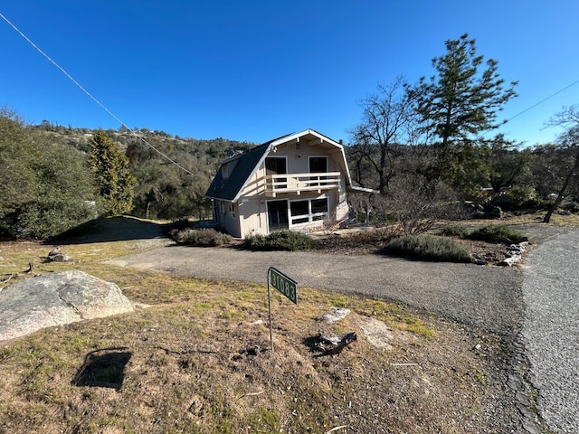 31083 Bear Paw Way, Coarsegold, CA 93614 - view of property exterior featuring a gambrel roof and a balcony
