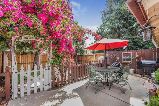 view of patio / terrace featuring outdoor dining space, fence private yard, and a grill
