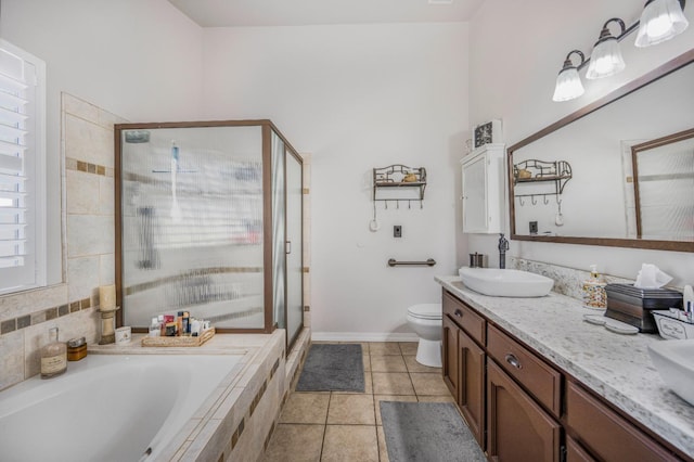 bathroom featuring tile patterned floors, toilet, a sink, a stall shower, and a garden tub