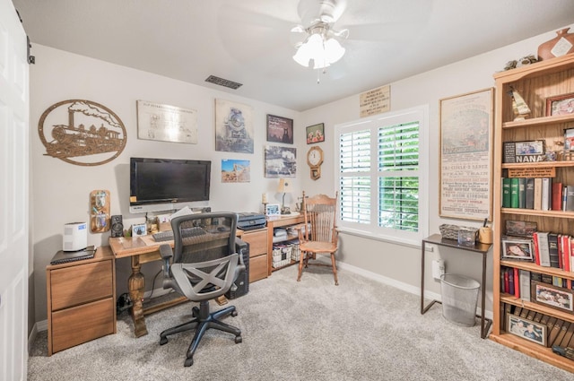 carpeted office space featuring visible vents, a ceiling fan, and baseboards