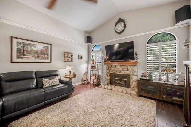 living room featuring a healthy amount of sunlight, wood finished floors, ceiling fan, and a stone fireplace