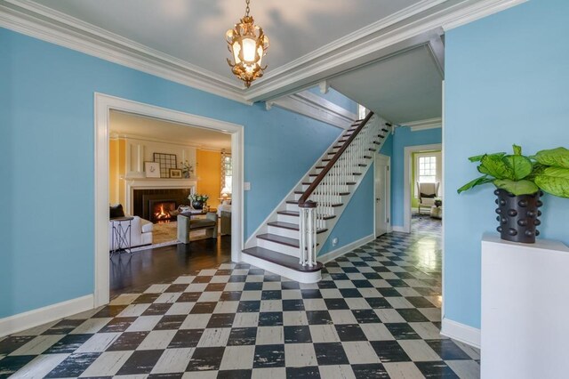 605 E Home Ave, Fresno, CA 93728 - entryway featuring baseboards, a warm lit fireplace, a notable chandelier, dark floors, and stairs