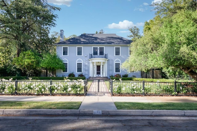 605 E Home Ave, Fresno, CA 93728 - colonial house featuring a fenced front yard, a gate, and stucco siding