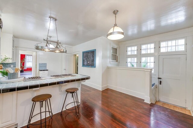 605 E Home Ave, Fresno, CA 93728 - kitchen with dark wood-type flooring, tile countertops, baseboards, and a breakfast bar